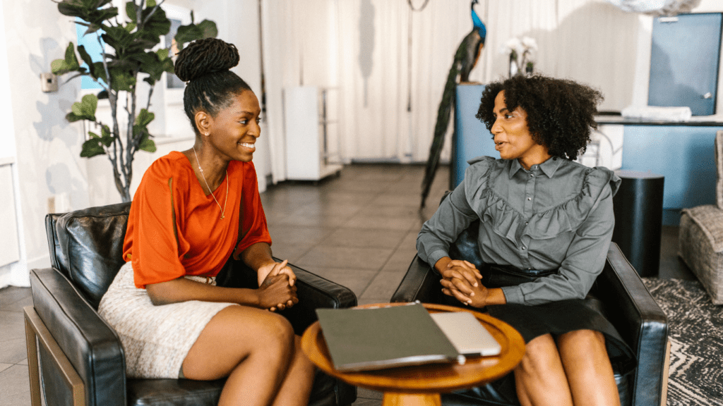 two woman discussing on the table