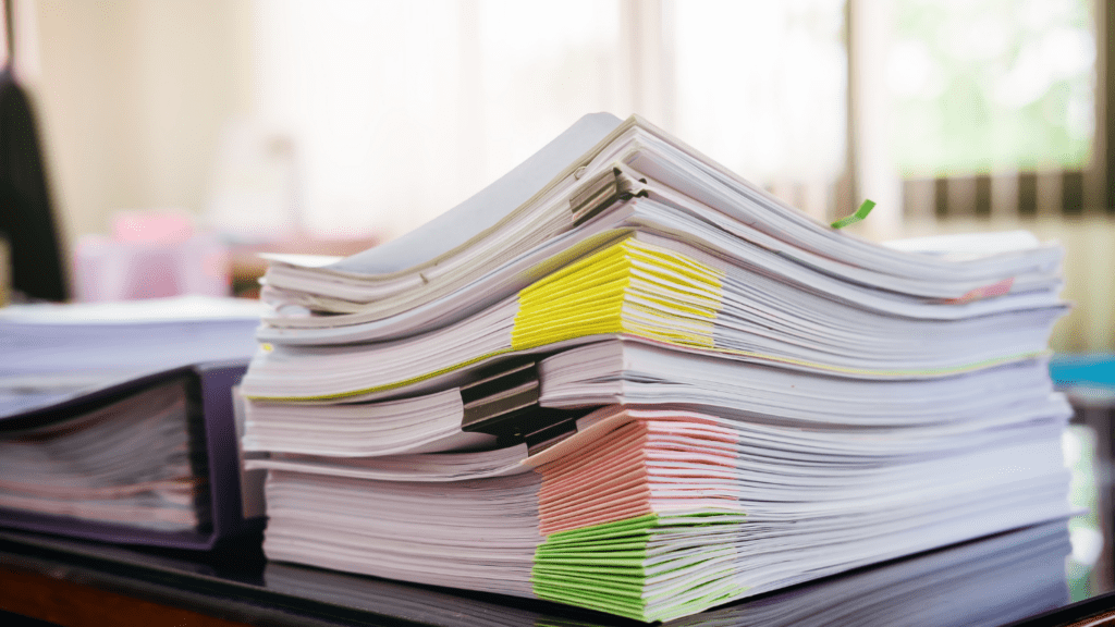 a stack of papers sitting on top of a desk