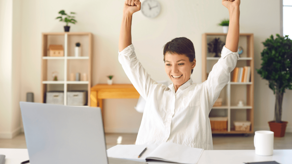 a person is sitting at a desk with their arms up in the air