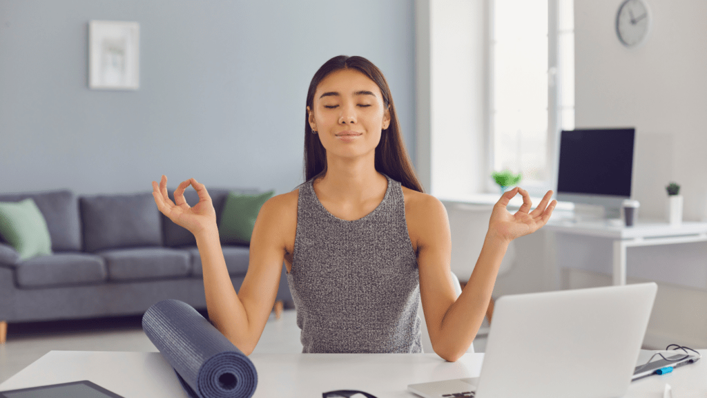 a person is sitting at a desk with their arms up in the air