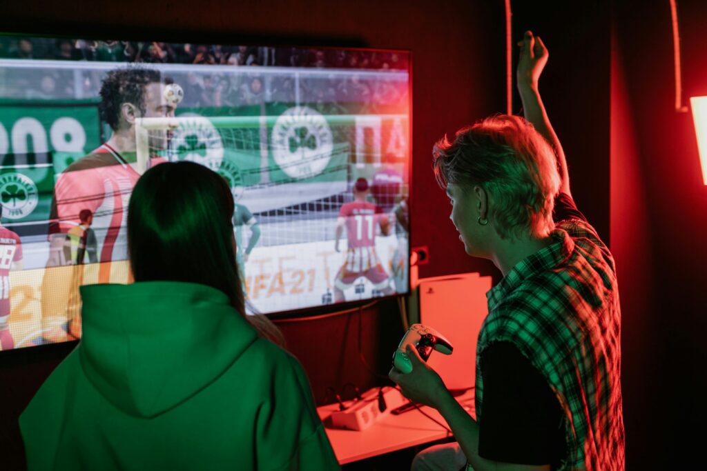 Two friends enjoying an exhilarating video game session indoors, captured with vibrant lighting.